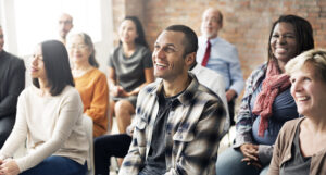 An audience laughing and looking attentively at their presenter (not pictured).