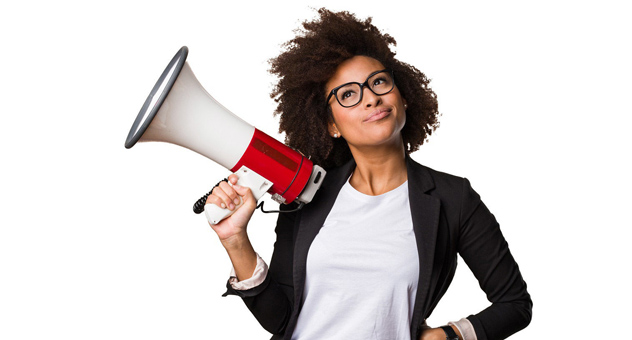 A woman in a suit jacket holding a megaphone.